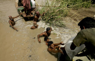 MATUTDELING:Marineoffiserer deler ut mat til flomofre n�r Sukkur i Sindh provinsen. Foto: Shakil Adil/AP/Scanpix