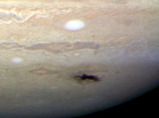 ST�VSUGER-PLANTETEN: Gasskjempen Jupiter fungerer heldigvis som solsystemets st�vsuger og har sugd til seg asteroider og kometer som ellers kan ha truffet Jorda. Men Jorda har opplevd katastrofale nedslag f�r, og vil i det lange l�p bli rammet igjen. Den sorte prikken i Jupiters atmosf�re p� bildet er fra et objekt som traff planeten i 2009. Foto: NASA