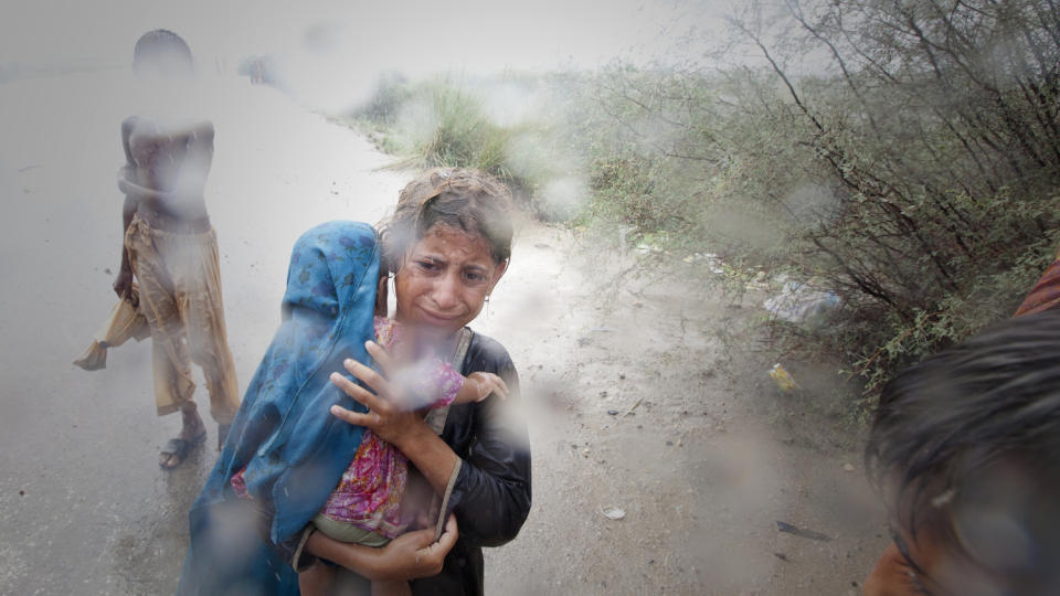 P� FLUKT: En jente i Punjabi-provinsen med en liten s�ster p� armen gr�ter etter � ha blitt robbet for risen hun hadde f�tt. Hun er en av flere millioner som er p� flukt som f�lge av flomkatastrofen i Pakistan. Foto: REUTERS/Adrees Latif/ SCANPIX.