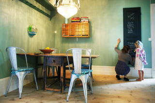 Nytt og gammelt: Nye Tolix-stoler og gammelt spisebord holder hverandre med selskap under krystall-lysekrona p� kj�kkenet. En tavle er ogs� grei � ha n�r det er mye � huske p�.
Foto: Nina Ruud