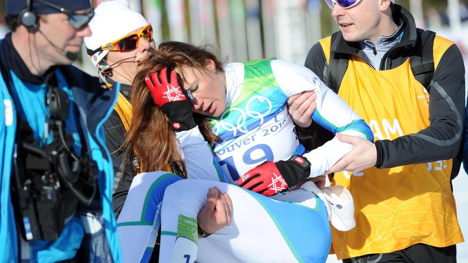 BLE B�RET VEKK FRA M�LOMR�DET: Petra Majdic var storfavoritt p� sprinten, men falt stygt under oppvarmingen og brakk fire ribbein. Likevel kjempet hun seg inn til OL-bronse - der hun segnet om i m�lomr�det etterp� og ble b�ret vekk av helsepersonell. Foto:   EPA/DANIEL DAL ZENNARO