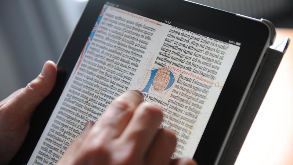 L�RER P� IPAD: En skole i Skotland satser n� p� iPad. Her leses Gutenbergs bibel p� Apple-maskinen. Foto: EPA/ANDREAS&nbsp;GEBERT/SCANPIX