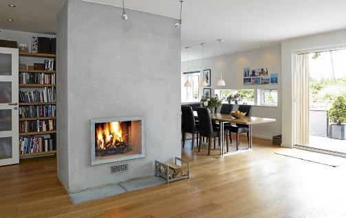 DELER ROMMET: Peisen ligger fritt i rommet, noe som bidrar til at det virker st�rre samtidig som den fungerer som romdeler. De avlange vinduene over spisebordet gir utmerket utsikt fra sitteh�yde. FOTO: Espen Gr�nli