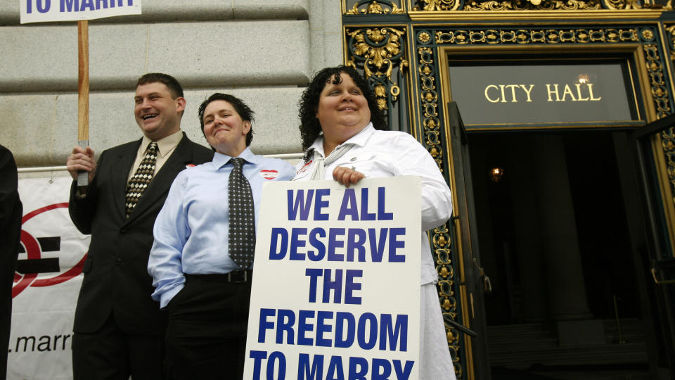  UT I DET BL�:  Et lesbisk par utenfor r�dhuset i San Fransisco i California demonstrerer for retten til � gifte seg. N� jakter SAS p� et homofilt par for � stelle i stand det f�rste homobryllupet om bord p� et passasjerfly. Foto: REUTERS / Robert Galbraith / SCANPIX.