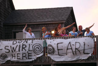 MANGE BLIR IGJEN: Familien Wood og Rollin vinker til biler som flykter fra orkanen Earl fra sin leide hytte i North Carolina. Familiene har bestemt seg for � bli v�rende til tross for advarsler. Foto: Mark Wilson/Getty Images/AFP