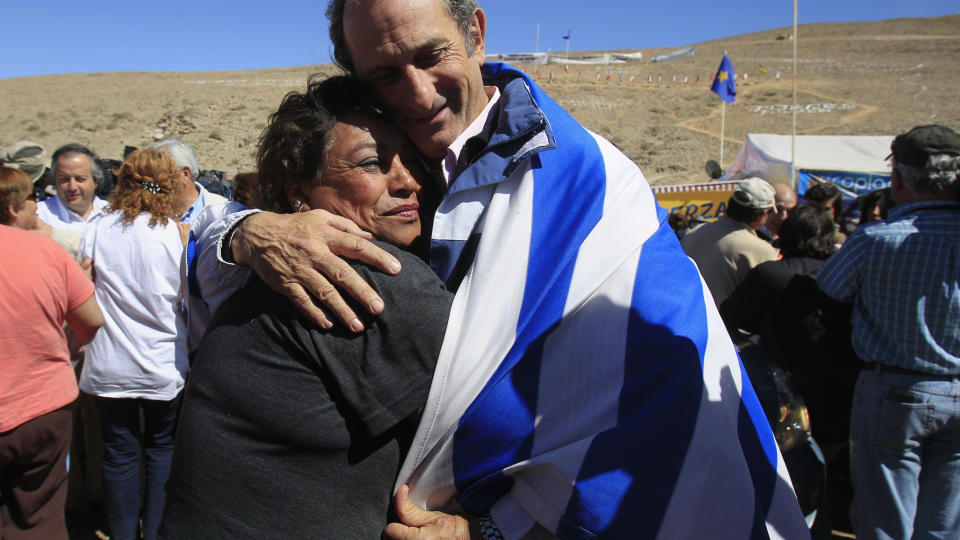 OVERLEVDE FLYSTYRT Gustavo Zerbino (t.h), som overlevde en flystyrt i 1972, tr�ster  Maria Segovia, s�ster av en av de innestengte gruvearbeiderne i San Jose gruva in Copiapo, Chile. Foto: AP/Martin Mejia