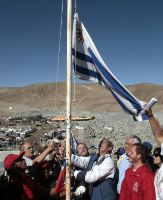 FORBR�DRING Pedro Algorta og Gustavo Zerbino heiser det uruguanske flagget til �re for de innestengte chilenske gruvearbeiderne og deres p�r�rende. Foto: REUTERS/Luis Higaldo