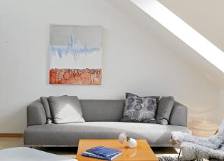 ENKELT M�BLERT: Stuen �pner seg mot allrommet og er innredet med f�, men tydelige m�bler. Sofaen er fra B & B Italia, bordet fra Floreani. Maleriet er et elevarbeid av en norsk kunststudent. Foto: Sveinung Br�then