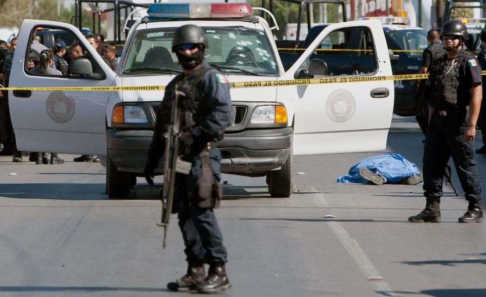 ENDA ET OFFER I DEN BLODIGE MEKSIKANSKE NARKOKRIGEN: F�deralt politi p� �stedet der en politimann ligger d�d igjen p� gata i Ciudad Juarez etter et blodig oppgj�r med et av de meksikanske narkokartellene. Den meksikanske narkokrigen har krevd mer enn 28000 liv siden 2006. Foto: Jesus Alcazar/AFP/Scanpix