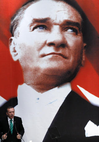 LANDSFADEREN: Mustafa Kemal, Atat�rk, skapte det moderne Tyrkia. Han var en knallhard sekularist som forb�d religi�se hodeplagg for menn, renset ut orientalsk innflytelse, innf�rte latinske bokstaver og vendte landet mot Vesten. Dagens statsminister til venstre. Foto: REUTERS/Umit Bektas
