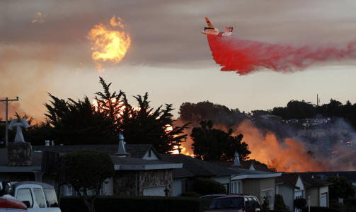 FLY OVER FLAMMENE: Det er satt inn fly og helikopter som skal forhindre spredning og sette en stopper for brannen. Foto: AP/Scanpix