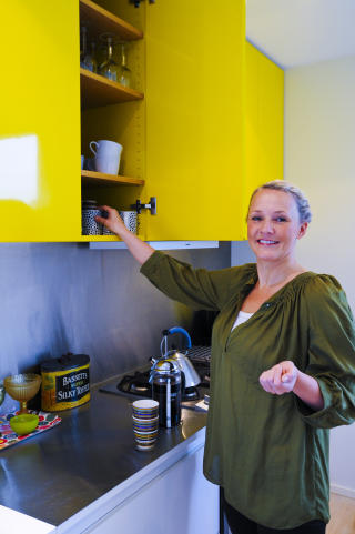 Forn�yd: Kj�kkenskapene krever sin oppmerksomhet, men Tuva Voll har blitt glad i gulfargen. Det var husarkitekten og designerbroren som kom med forslaget om knallgule overskap p� kj�kkenet. Foto: Anniken Zahl Furunes.