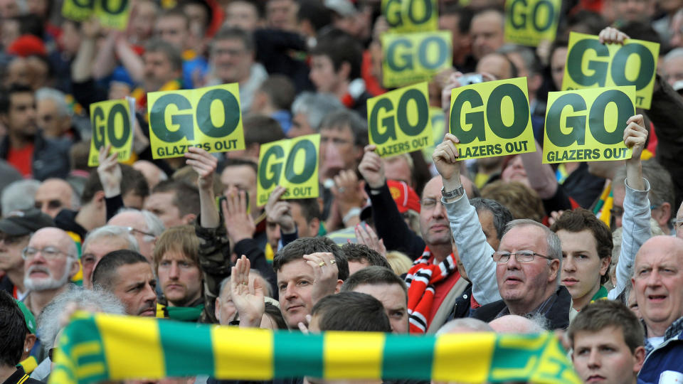GUL OG GR�NN TIL KLUBBEN ER SOLGT: United-supporterne har ikledd seg opprinnelsesfargene til klubben, i protest mot eierfamilien. Foto: AFP/ANDREW YATES
