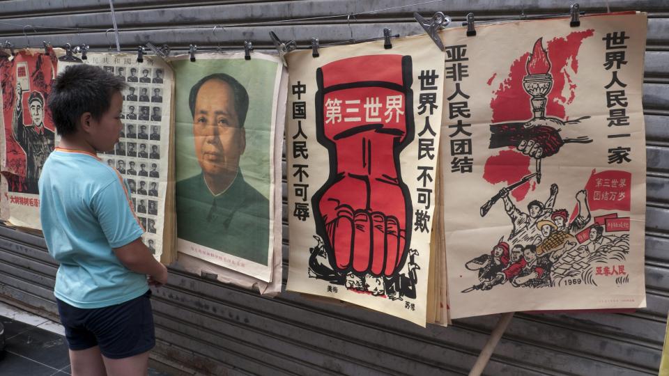 HARDE ANKLAGER: En ung gutt ser p� reproduserte propagandaplakater fra 60-tallets Kina. Lite har endret seg til det bedre n�r det gjelder sensur og manglende frihet, mener undertegnerne av det sv�rt kritiske oppropet vi her trykker et utdrag fra.  Foto: EPA/Scanpix