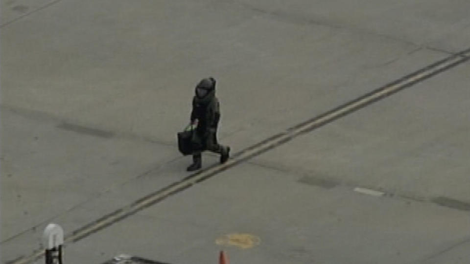 B�RES BORT: Her b�rer en bombetekniker bort en pakke fra UPS-flyet som ble isolert i Newark i New Jersey.