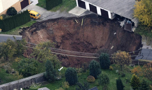 SUGD NED: En bil og en garasjed�r havnet p� bunnen av det gigantiske krateret. Foto: REUTERS/Alex Domanski/Scanpix