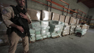 STORBESLAG: En politiagent for amerikanske toll- og immigrasjonsmyndigheter vokter blokkene med marijhuana som ble beslaglagt da amerikansk politi stanset et ektepar. Politiet fant en velutstyrt smuglertunnel mellom California i USA og Tijuana i Mexico. Foto: REUTERS/Nelvin C. Cepeda/San Diego Union-Tribune/Pool