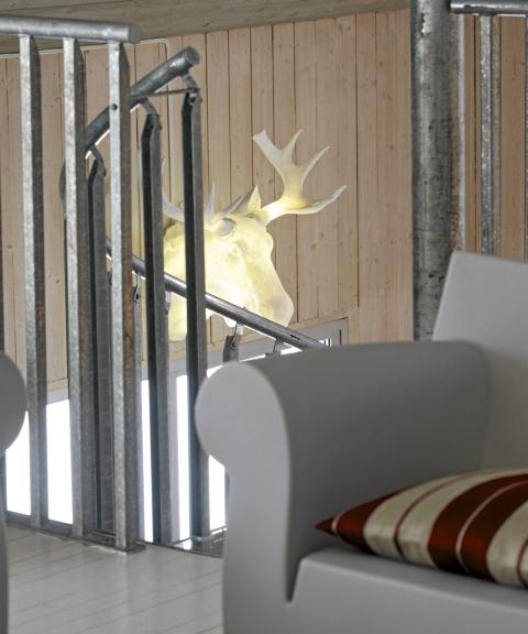 LYSENDE ELGHODE: Astrid og Willy n�yer seg med et elghode fra Nordic Lighting i trappeoppgangen. Den ekte varen vandrer i skogen utenfor. Foto: Ragnar Hartvig