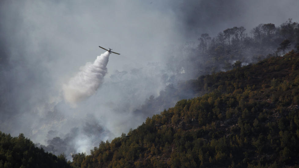 NORGE SKAL BIST�: Her er et fly i sving over fjellet Camel i n�rheten av byen Haifa nord i Israel. N� skal Norge bist� med ett helikopter med mannskap i kampen mot flammene. Foto: REUTERS/Nir Elias/Scanpix