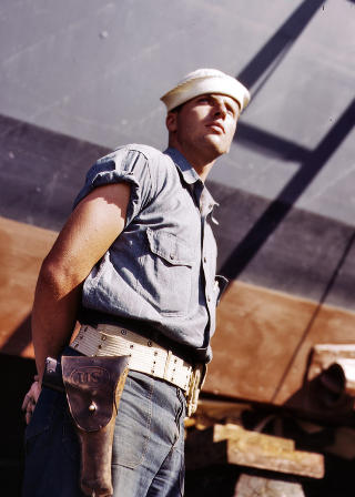  OPPRINNELIG BILDEINFORMASJON:   New Orleans, July 1942. Coast Guardsman standing watch over 78-foot torpedo boat. Continual watch is kept. Higgins Industries Inc.4x5 Kodachrome transparency by Howard Hollem for the Office of War Information.  Du kan se hele den enorme samlingen fra Office of War Information i lenken nederst i saken.