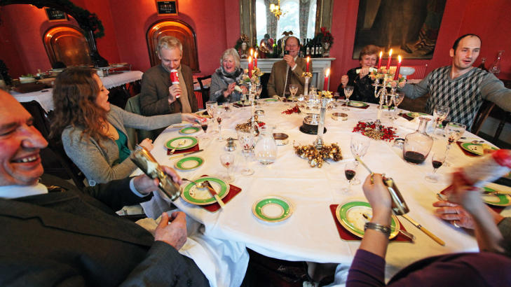 JULEFEST: Julian Assange spiste en tradisjonsrik julemiddag sammen med husvert Vaughan Smith, familie og venner. P� bildet betrakter Assange smellbonbon-en han vant. Foto: Robert King / Polaris / Scanpix
