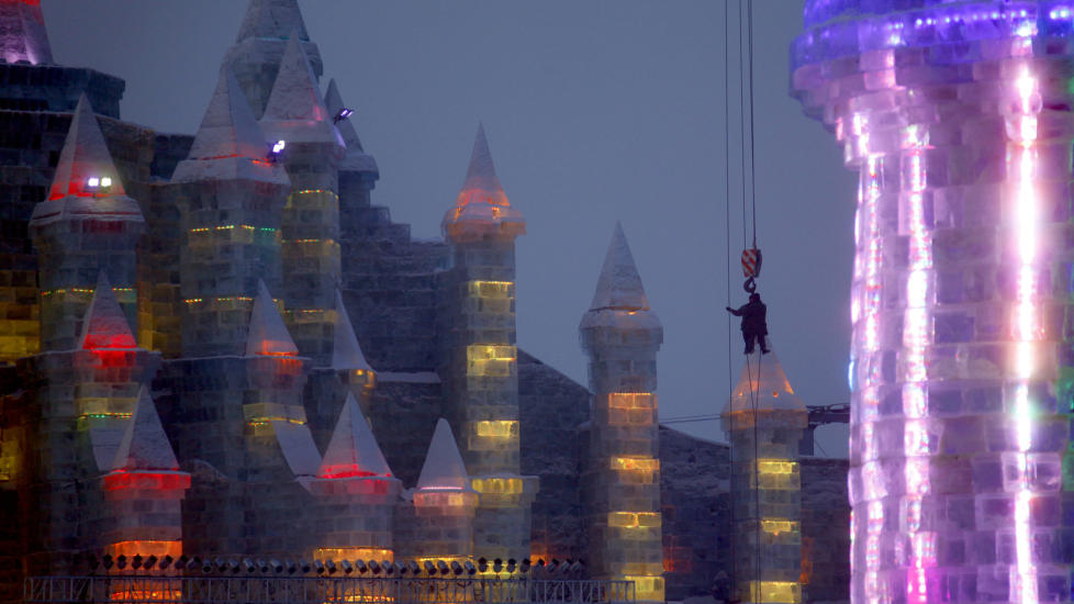 KALD KONSTRUKSJON: En arbeider henger fra ei kran mens han gj�r siste finpuss p� en isskulptur i byen Harbin nord i Heilongjiang-provinsen i Kina. Foto:Reuters/David Gray/Scanpix