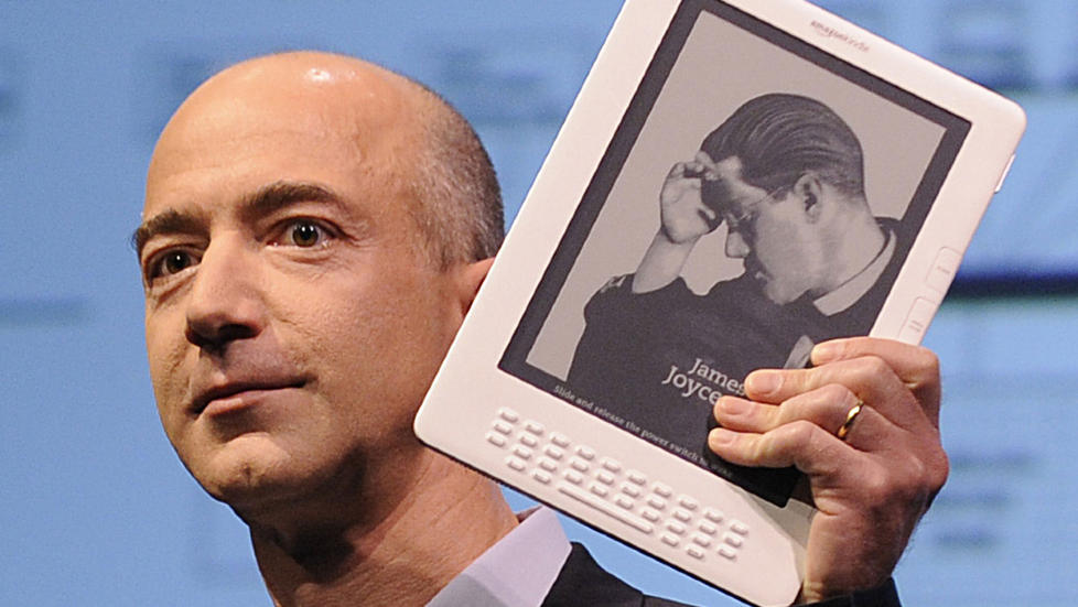FRAMTIDA: Amazon-sjef Jeff Bezos viser fram lesebrettet Kindle. Det er nettbokhandlene og ebokhandlene som har det store mangfoldet og utvalget, som selger bredden og den smale litteraturen, skriver forlegger Ivar Tronsmo. Foto: Scanpix