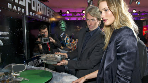 SKJ�NNHETEN OG ACTIONUDYRET: Michael Bay l�rer her Rosie Huntington-Whiteley ett og annet om Transformers-universet. Foto: Reuters/Ray Stubblebine/Scanpix