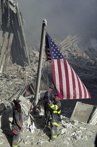 RUINER: Brannmenn fra New Yorks brannvesen reiser flagg i ruinene etter World Trade Center dagen da tvillingt�rnene falt mot jorden.Foto: AP Photo/ The Journal News, Ricky Flores