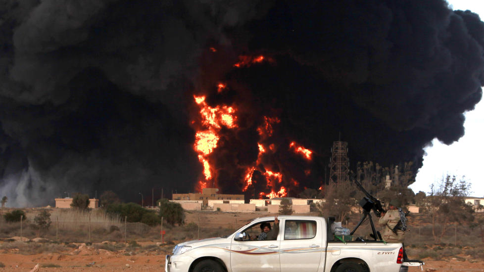 I BRANN: En oljeterminal st�r i brann etter at den ble truffet av pro-Kadhafi-styrker under kampenene om den viktige oljebyen Ras Lanuf. Foto: REUTERS/Asmaa Waguih/Scanpix
