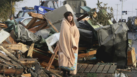 MIDT I KATASTROFEN: En kvinne st�r i ruinene i byen Ishimaki etter jordskjelvet og tsunamien som rammet Japan fredag. Foto: REUTERS / Yomiuri Shimbun / SCANPIX