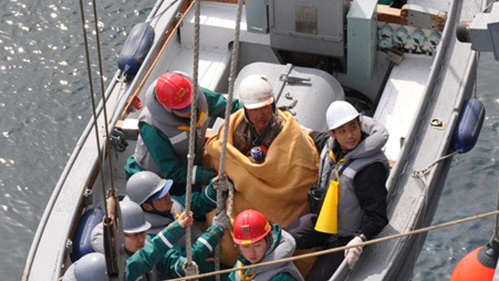 REDDET: 60 �r gamle Hiromitsu Shinkawa har f�tt et varmt teppe rundt seg etter at han ble reddet 15 kilometer til havs. Foto: Det japanske forsvarsdepartement/AP/Scanpix