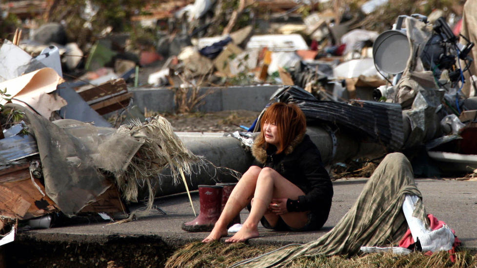 JAPAN I SORG:  En kvinne gr�ter blant restene av byen Natori, som er �delagt av jordskjelv og tsunami. REUTERS/Asahi Shimbun