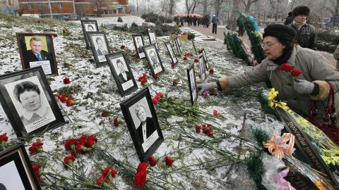 HEDRER SINE D�DE: En kvinne legger ned blomster p� minnesmerket i Kiev. Her hedres de som ofret livet ved Tsjernobyl. Foto: EPA/SERGEY DOLZHENKO