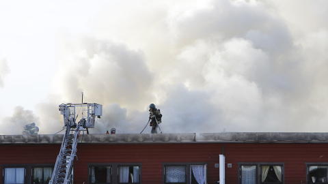 SLUKKER: Brannmannskaper fortsetter n� slukningsarbeidet etter at en boligblokk i Rykkinn tok fyr i dag morges. Foto: H�kon Mosvold Larsen / Scanpix