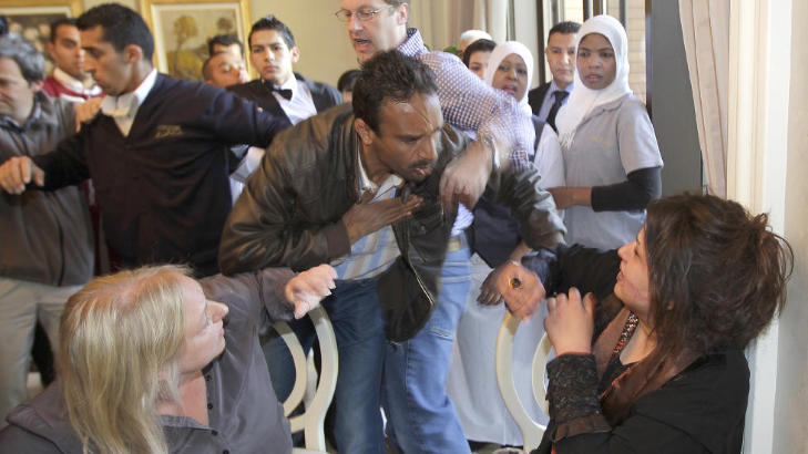 VILLE FORTELLE SIN HISTORIE:: En mann fra libyske myndigheter fors�ker � stanse Eman al-Obeidi p� pressehotellet i g�r. I bakgrunnen fors�ker Financial Times sin journalist Charles Clover � hindre han igjen. al-Obeidi hevder hun ble gruppevoldtatt av 15 menn fra Kadhafi-regimet etter at hun ble arrestert. Foto: AP/Jerome Delay/SCANPIX