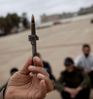 - HVA HETER DETTE?  Sp�r eks-milit�rmannen Nouri Tawil og tar en teknisk gjennomgang av den ene kalashnikoven folkeh�ren har disponibel til v�penoppl�ring. Hvoretter de rundt 90 libyerne roper svaret tilbake. Foto: Tomm W. Christiansen