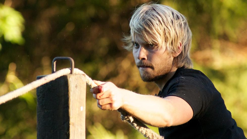 R�K UT: Deltakerne Morten Emil Bergan (bildet) og Jan Rudi Bendiksen konkurrerte om � bli f�rst til � f� tak i tre hestesko som var plassert i hver ende av tauet. Etter nesten to timer med tautrekking var det Bergan som m�tte forlate �Farmen�. Foto: TV2