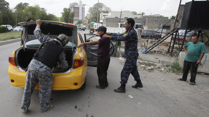 SKJERPET OGS� I IRAK: Ogs� i Irak har sikkerheten blitt skjerpet etter den amerikanske operasjonen. Her blir en person unders�kt av irakisk politi p� en kontrollpost i Bagdda i Irak. Foto: AP Photo/Karim Kadim/Scanpix