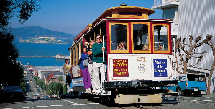 KLASSISK BYBILDE: Kabelbane p� vei opp en av San Franciscos bratte gater med Alcatraz, �The Rock�, i bakgrunnen.  Foto: California Turistkontor