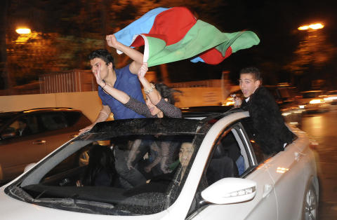 FEIRET I NATT: Hundrevis av mennesker samlet seg rundt plassen Azadlig i sentrum av Baku. De svingte det aserbajdanske flagget og ropte Aserbajdsjan!, Aserbajdsjan!  Foto: Osman Karimov / Reuters / Scanpix