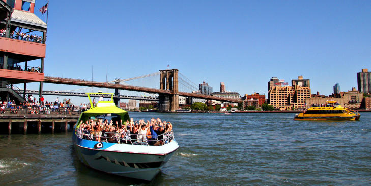SOUTH STREET SEAPORT: Sommerens heteste uteomr�de. Speedb�ten Shark legger ut fra Pier 17, mens den gule New York Water Taxi er p� vei fra Brooklyn-brua. Foto: KIRSTEN M. BUZZI