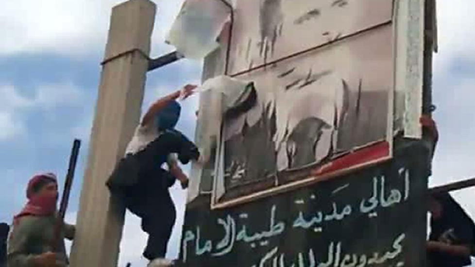 OPPR�RET FORTSETTER: Dette bildet fra en You Tube-film viser demonstranter i den syriske byen Taibet al-Imam, nord for Damascus, som river ned en plakat av de syriske presidenten i dag. Foto: AFP PHOTO/YOUTUBE