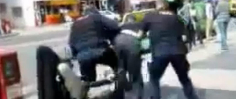 Her slenger politiet rullestolbrukeren p� ansiktet i asfalten