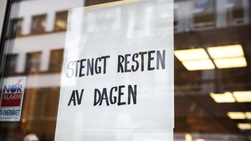 EVAKUERT: En politimann kikker inn gjennom vinduet til bokhandelen Halvbroren og lokalene til Cappelen Damm i Akersgata mandag. Det er varslet demonstrasjoner etter at forlaget besluttet � utgi en bok med Muhammed-karikaturer. Foto: Erlend Aas / Scanpix
