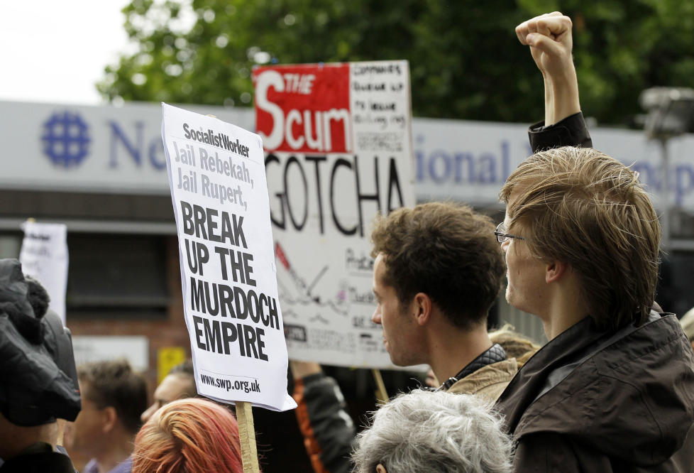 KREVER BLOD: Rasende britiske demonstranter krever en slutt p� det de kaller Rupert Murdochs �imperium�, og forlanger at han og tidligere News of the World-redakt�r Rebekah Brooks blir fengslet. Foto: SANG TAN / AP / SCANPIX