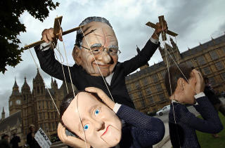  MARIONETTDUKKER:  En demonstrant utkledd som Rupert Morduch lekte seg med tanken om at det er nettopp slik mediemogulen styrer makta. Dukkene h�rer til David Cameron og kultur-, medie- og sportsministeren Jeremy Hunt. Foto: AFP PHOTO/ADRIAN DENNIS