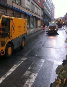 Rydder vekk glasskår og støv etter bomben