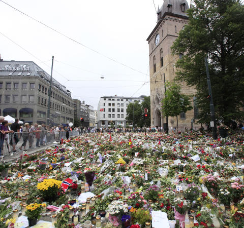 BLOMSTERHAV: Utenfor Domkirka i Oslo har det str�mmet p� med folk som �nsker � legge ned blomster for � minnes ofrene. Foto: Erik Johansen / Scanpix .