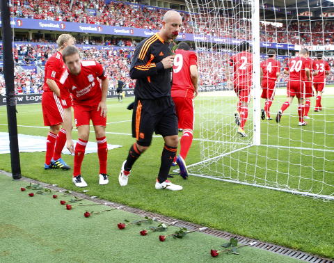 LA NED ROSER: Liverpool-spillerne la ned roser til minne om ofrene p� Ut�ya og i Oslo f�r kampen. Foto: H�kon Mosvold Larsen / Scanpix